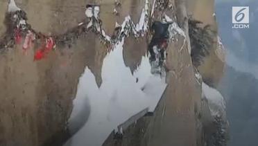 Bikin Ngilu, Aksi Tukang Sapu Bersihkan Salju di Tebing