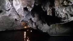 Rowing the boat through a dark cave in Trang An